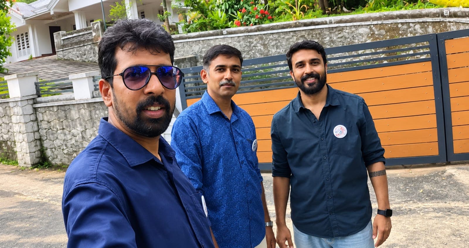 Three of the GetCareIndia founders, wearing GetCareIndia badges, outside a care home in Kerala